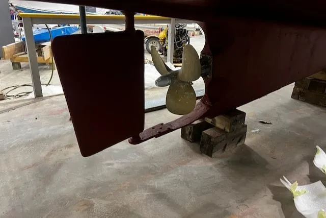 Slide: The Image of 1984 Grand Banks Trawler propeller and rudder in a workshop setting. - 42