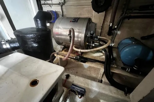 Slide: The Image of Engine room of a 1984 Grand Banks Trawler, featuring mechanical components and piping. - 48