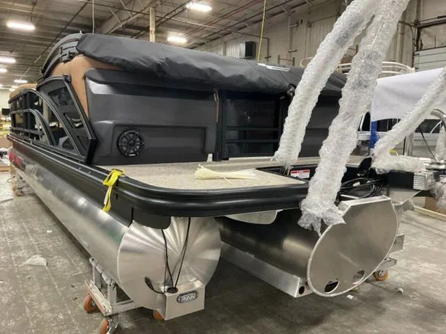 Slide: The Image of 2025 Bennington M Quad Bench 26 MFB pontoon boat in a warehouse setting. - 11