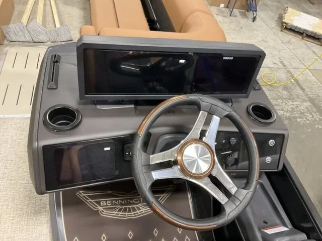 Slide: The Image of Steering console of 2025 Bennington M Quad Bench 26 MFB with dual screens and cup holders. - 3