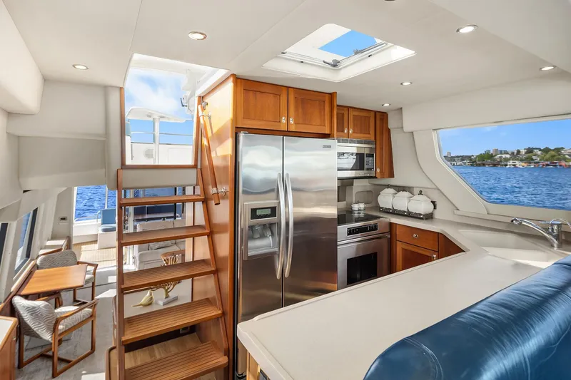 Slide: The Image of Luxurious 2003 Pacific Mariner Pilothouse yacht interior with modern kitchen and scenic water view. - 12