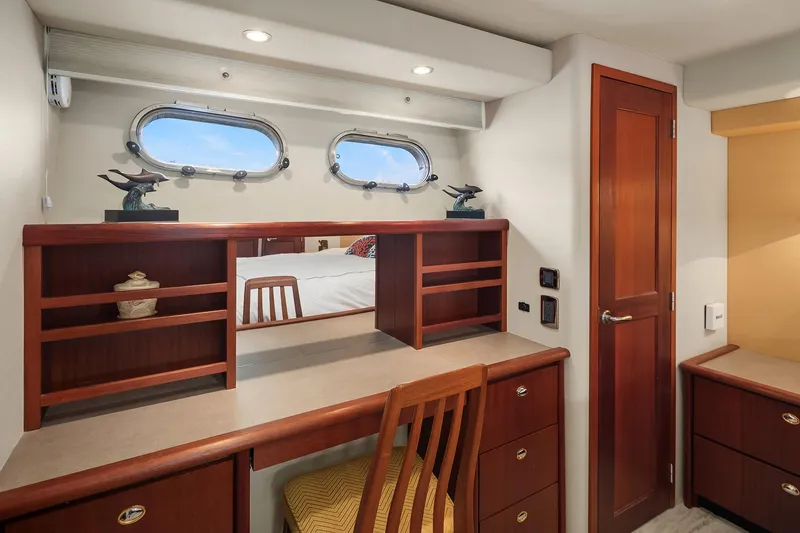 Slide: The Image of 2003 Pacific Mariner Pilothouse interior with wooden desk, chair, and porthole windows. - 22