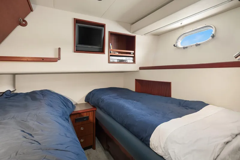 Slide: The Image of 2003 Pacific Mariner Pilothouse cabin with twin beds, porthole, and TV. - 26