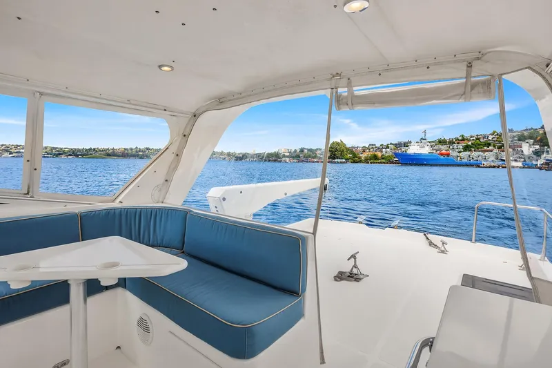 Slide: The Image of 2003 Pacific Mariner Pilothouse yacht interior with blue seating, overlooking serene waters and distant shoreline. - 31