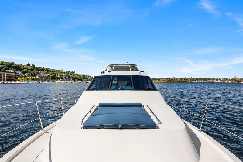 Slide: The Image of 2003 Pacific Mariner Pilothouse yacht cruising on a serene lake under a clear blue sky. - 34