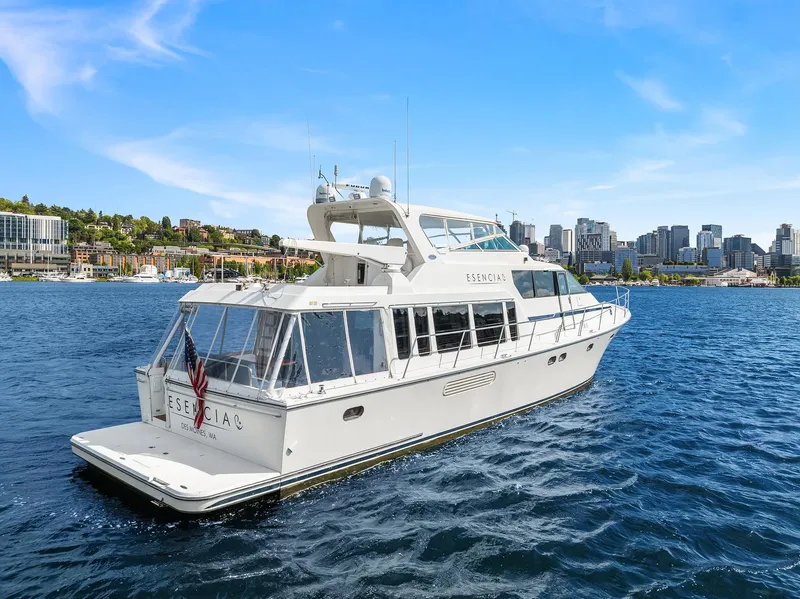 Slide: The Image of 2003 Pacific Mariner Pilothouse yacht cruising on a sunny day with city skyline in background. - 43