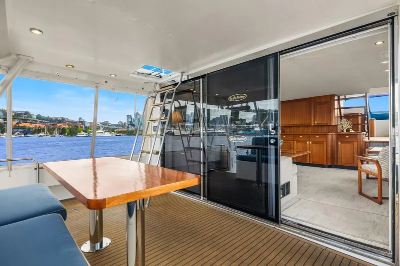 Slide: The Image of 2003 Pacific Mariner Pilothouse yacht interior with wooden table, seating, and waterfront view. - 5