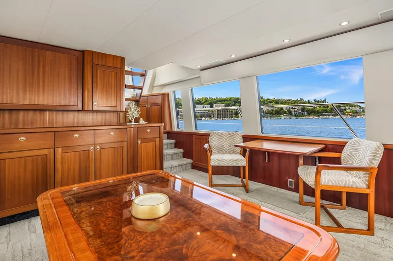Slide: The Image of Luxurious interior of 2003 Pacific Mariner Pilothouse yacht with elegant wood furnishings and scenic water view. - 9