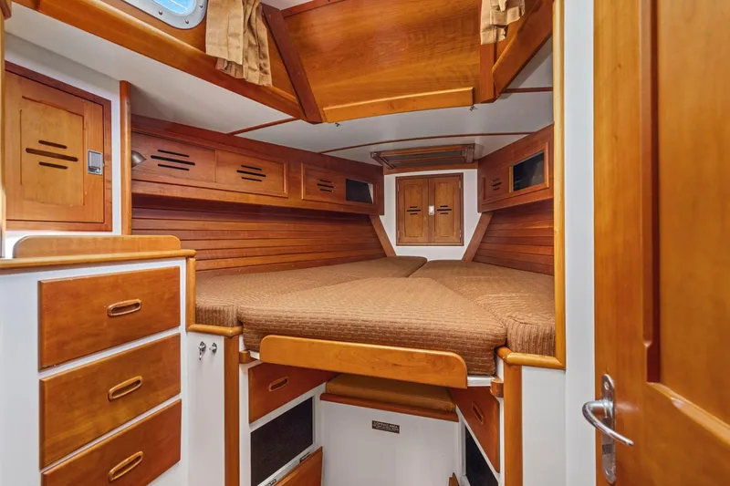 Slide: The Image of 1987 Hinckley Sou'wester 42 cabin interior with wooden finish and cozy bedding. - 38