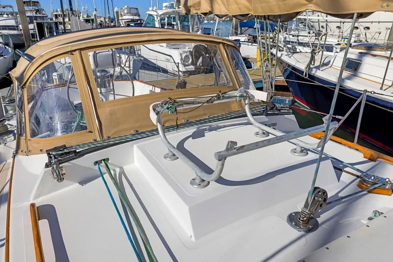 Slide: The Image of 1987 Hinckley Sou'wester 42 sailboat deck with tan canopy in marina. - 12