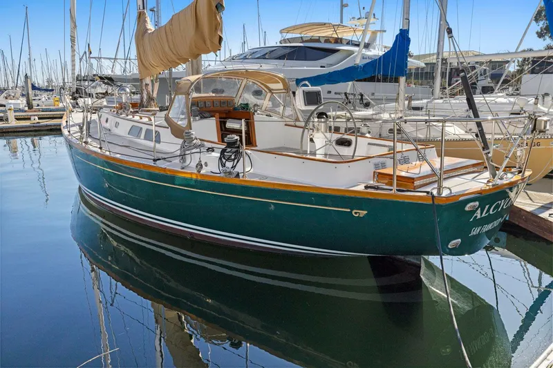 Slide: The Image of 1987 Hinckley Sou'wester 42 sailboat docked in a marina, reflecting on calm water. - 2