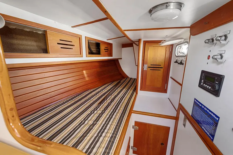 Slide: The Image of Interior of 1987 Hinckley Sou'wester 42 sailboat with wooden accents and striped bedding. - 28
