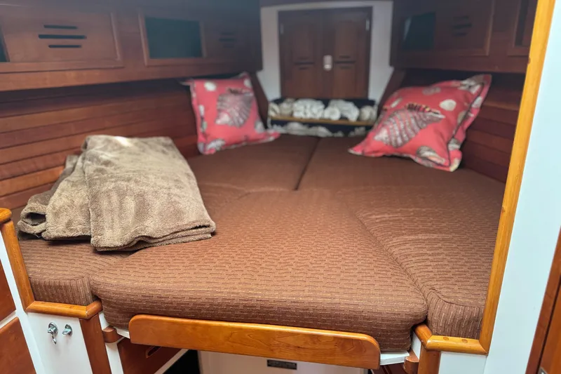 Slide: The Image of Cozy cabin interior of 1987 Hinckley Sou'wester 42 sailboat with brown bedding and decorative pillows. - 39