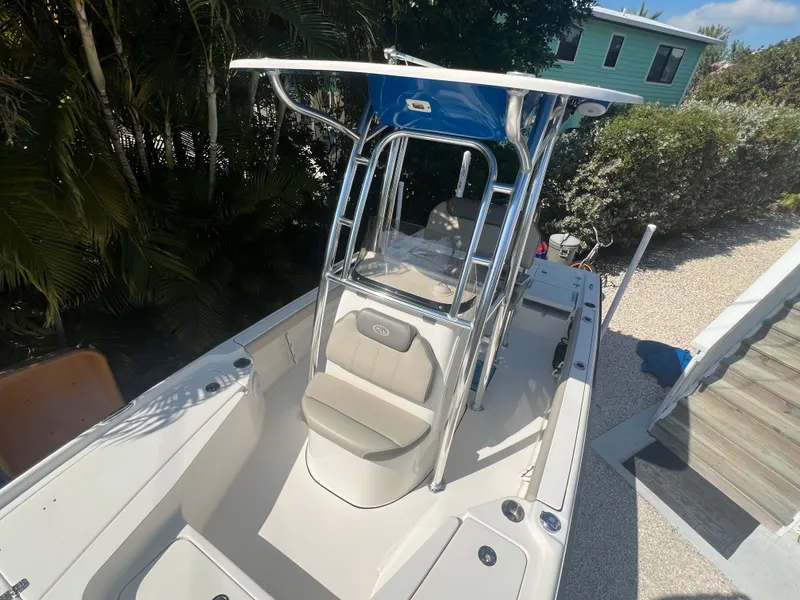 Slide: The Image of 2021 Key West 210 Bay Reef boat with T-top, parked outdoors. - 10