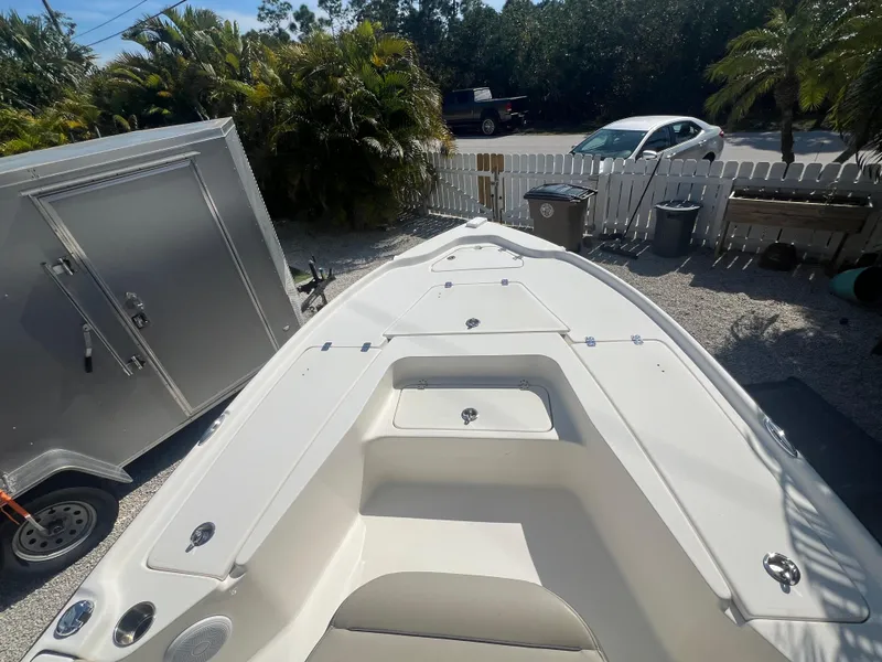 Slide: The Image of 2021 Key West 210 Bay Reef boat parked outdoors near trailer and white fence. - 12