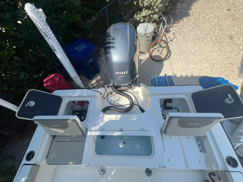 Slide: The Image of 2021 Key West 210 Bay Reef boat with open compartments and outboard motor. - 16