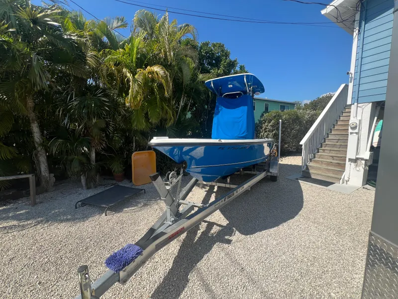 Slide: The Image of 2021 Key West 210 Bay Reef boat on trailer, parked in a sunny driveway. - 5