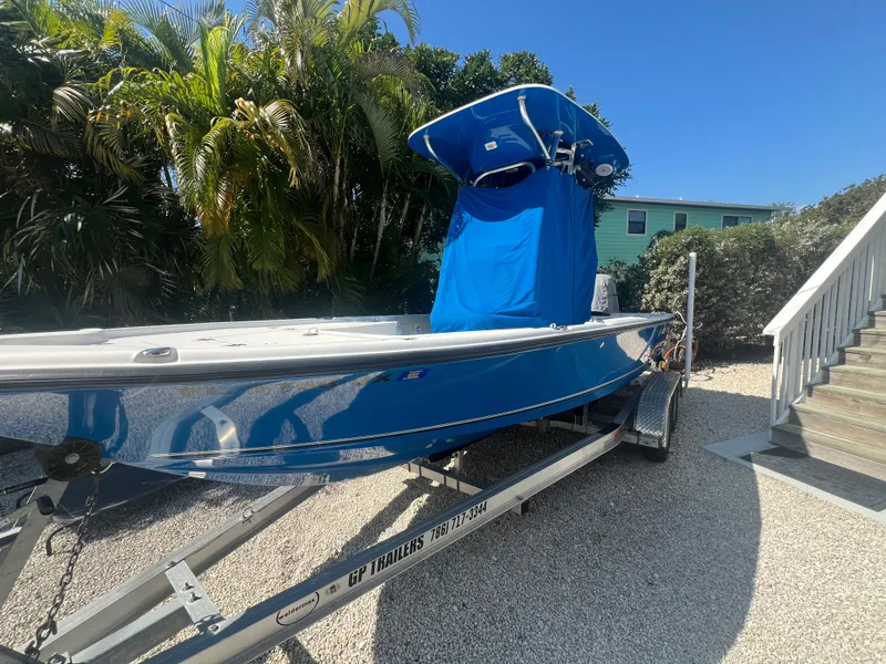 Slide: The Image of 2021 Key West 210 Bay Reef boat on trailer, surrounded by tropical foliage. - 7