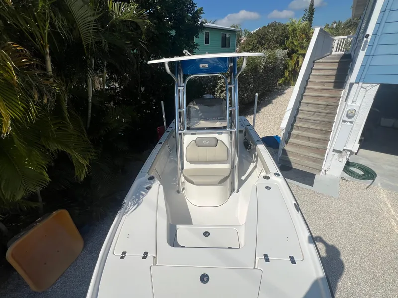 Slide: The Image of 2021 Key West 210 Bay Reef boat parked outdoors, surrounded by trees and a house. - 9