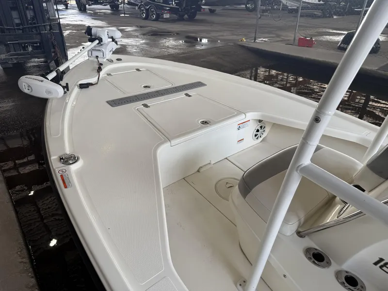 Slide: The Image of 2021 Mako 18 LTS boat interior with trolling motor in a garage setting. - 15