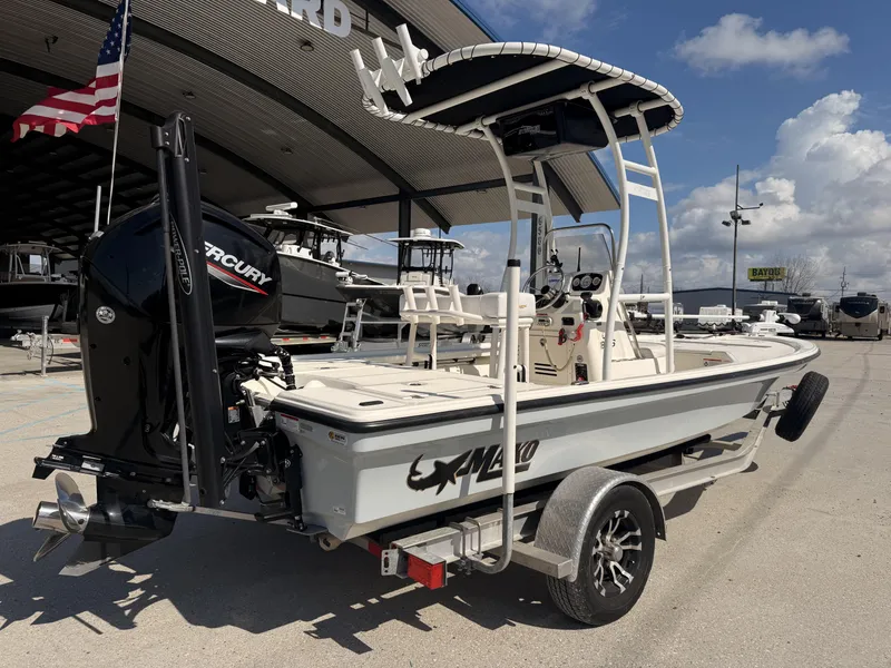 Slide: The Image of 2021 Mako 18 LTS boat with Mercury engine, parked outdoors under a clear sky. - 21