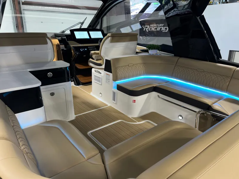 Slide: The Image of Luxurious seating area on 2025 Sea Ray Sundancer 370 OB with ambient blue lighting. - 24