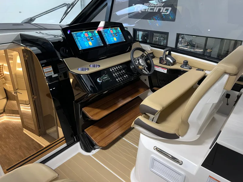 Slide: The Image of 2025 Sea Ray Sundancer 370 OB cockpit with modern navigation displays and cozy cabin interior. - 27