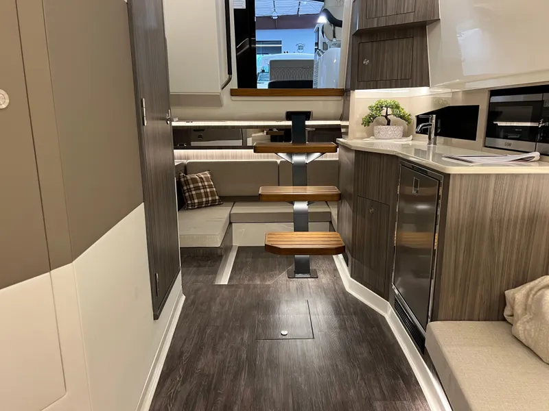 Slide: The Image of Interior of 2025 Sea Ray Sundancer 370 OB with modern wood finishes and cozy seating area. - 34