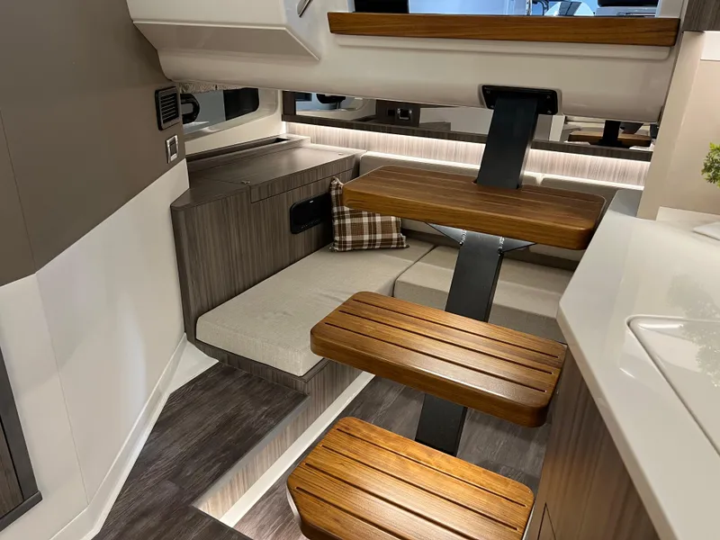 Slide: The Image of 2025 Sea Ray Sundancer 370 OB interior with cozy seating and plaid pillow. - 36