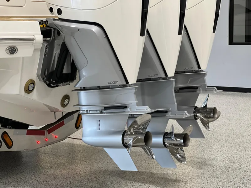 Slide: The Image of 2025 Sea Ray Sundancer 370 OB outboard engines with triple propellers in a showroom. - 7