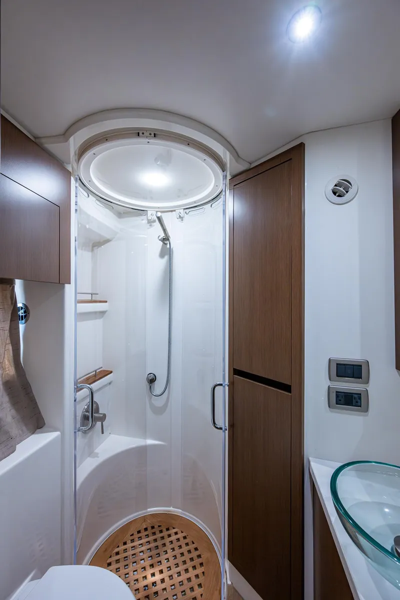 Slide: The Image of 2017 Sea Ray Sundancer 400 yacht bathroom with modern shower and wooden accents. - 41