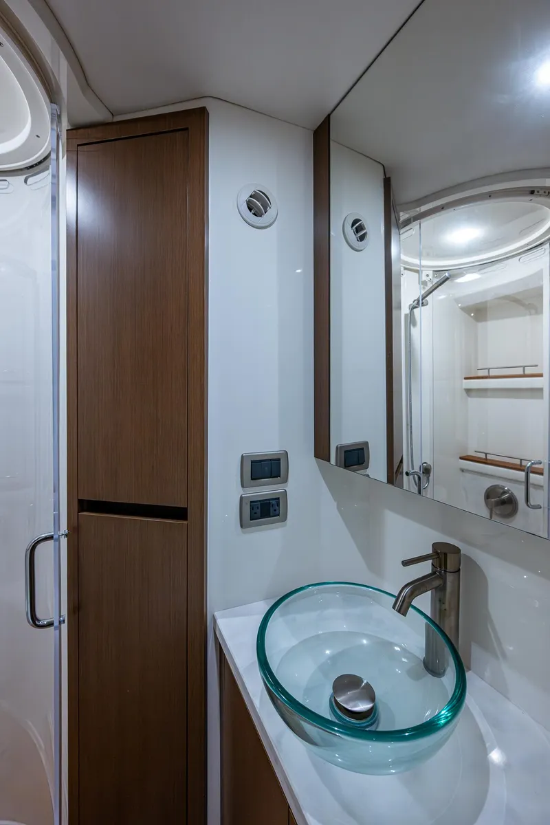 Slide: The Image of 2017 Sea Ray Sundancer 400 bathroom with modern glass sink and sleek wood cabinetry. - 42
