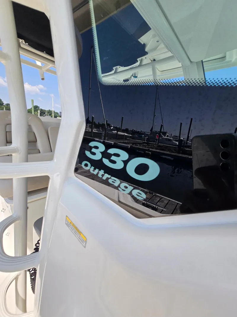 Slide: The Image of 2017 Boston Whaler 330 Outrage boat, close-up view of model name on window. - 12