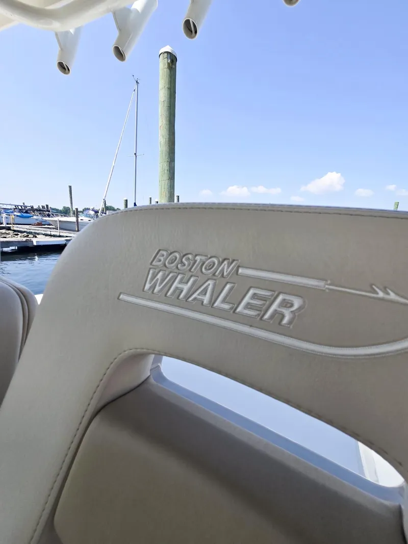 Slide: The Image of Boston Whaler 330 Outrage 2017 boat seat with logo, docked at marina. - 17