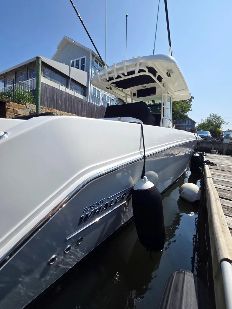 Slide: The Image of 2017 Boston Whaler 330 Outrage docked, side view with fenders, sunny day. - 19