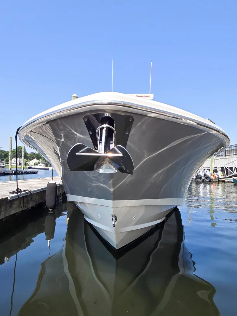 Slide: The Image of 2017 Boston Whaler 330 Outrage boat docked, front view, reflecting on calm water. - 6