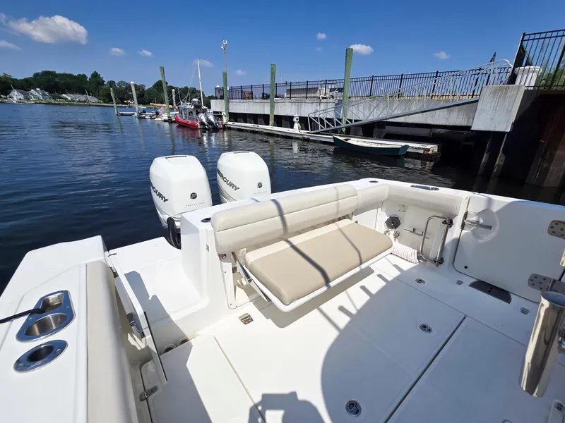 Slide: The Image of 2017 Boston Whaler 330 Outrage boat docked, featuring dual engines and spacious seating. - 9