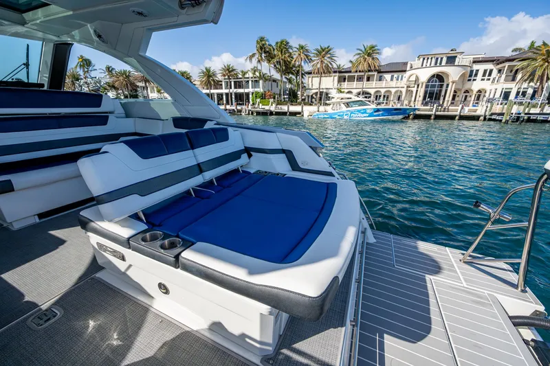 Slide: The Image of 2021 Formula 380 Super Sport Crossover OB, luxury boat with blue seating, docked by waterfront homes. - 27
