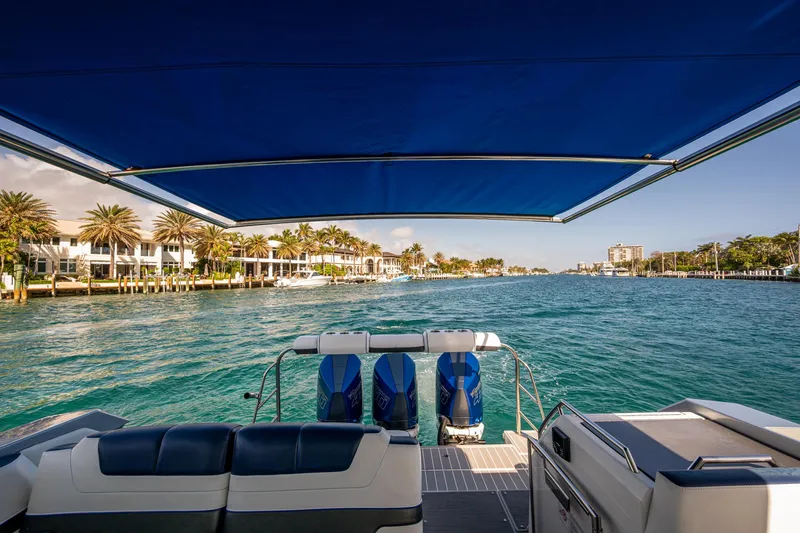 Slide: The Image of 2021 Formula 380 Super Sport Crossover OB cruising on a scenic waterfront with palm trees. - 44