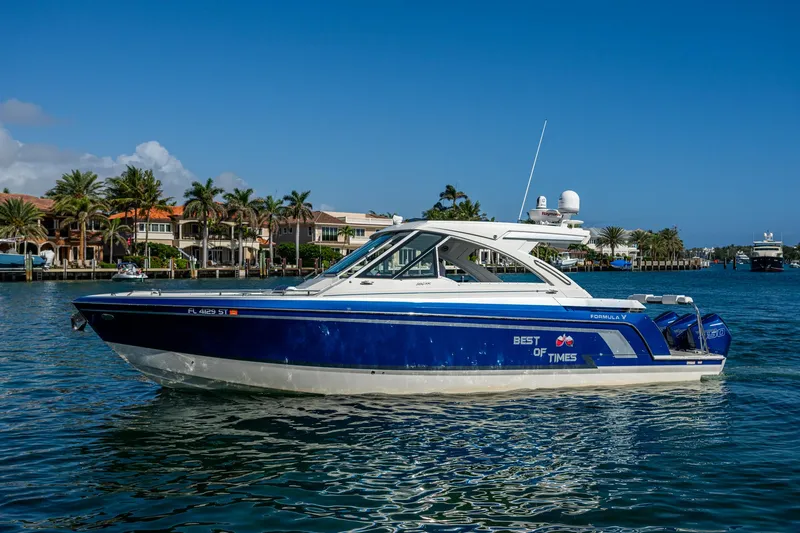 Slide: The Image of 2021 Formula 380 Super Sport Crossover OB boat on water, blue hull, luxury waterfront homes. - 49