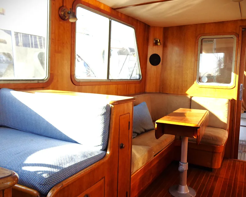 Slide: The Image of Interior of 1990 Pettegrow 36 Flybridge with wooden furnishings and blue seating. - 3
