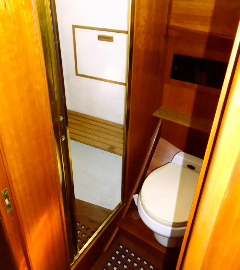 Slide: The Image of 1990 Pettegrow 36 Flybridge yacht bathroom with wooden interior and compact toilet. - 8