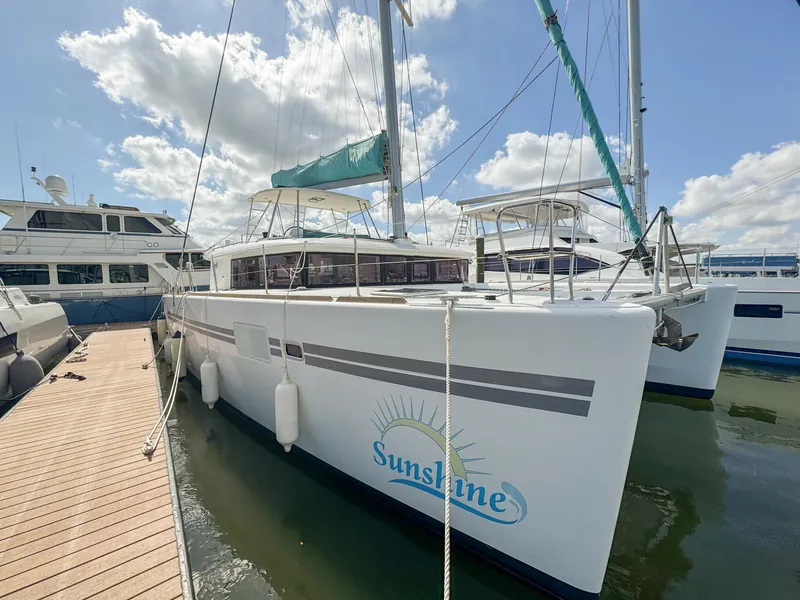 Slide: The Image of 2017 Lagoon 450 F catamaran docked, featuring "Sunshine" branding under a clear sky. - 0
