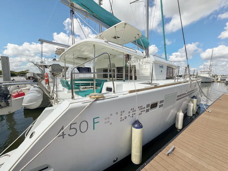 Slide: The Image of 2017 Lagoon 450 F catamaran docked at marina, featuring spacious deck and modern design. - 1