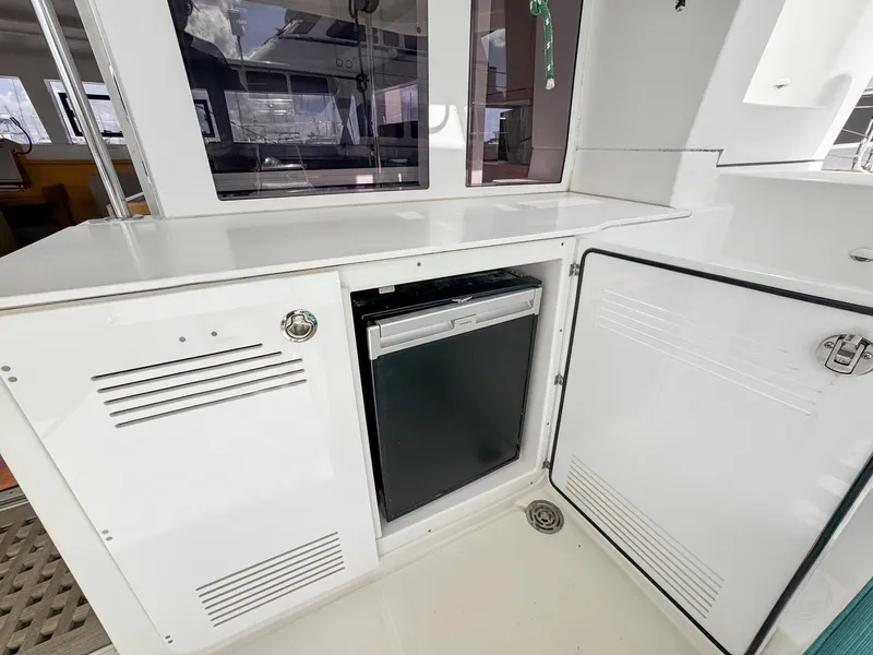 Slide: The Image of 2017 Lagoon 450 F yacht interior with open storage and mini fridge. - 10