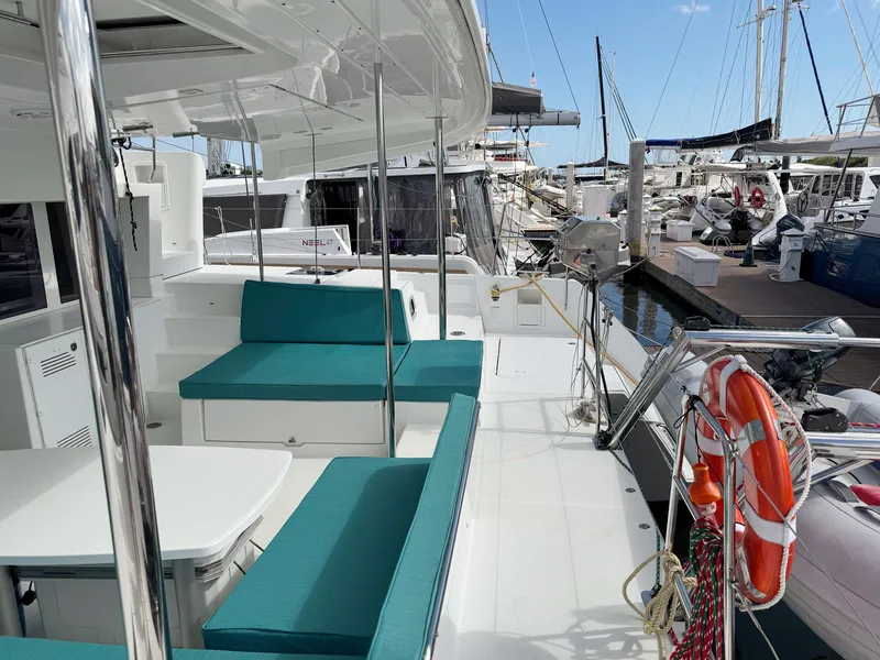 Slide: The Image of 2017 Lagoon 450 F catamaran with teal seating, docked at a marina. - 11