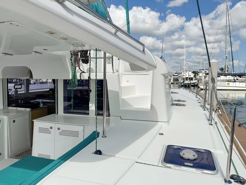 Slide: The Image of 2017 Lagoon 450 F catamaran deck with marina view, featuring sleek design and clear skies. - 13