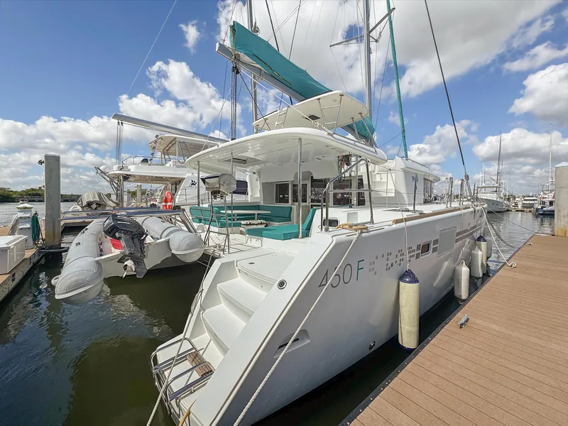 Slide: The Image of 2017 Lagoon 450 F catamaran docked at marina under blue sky. - 2