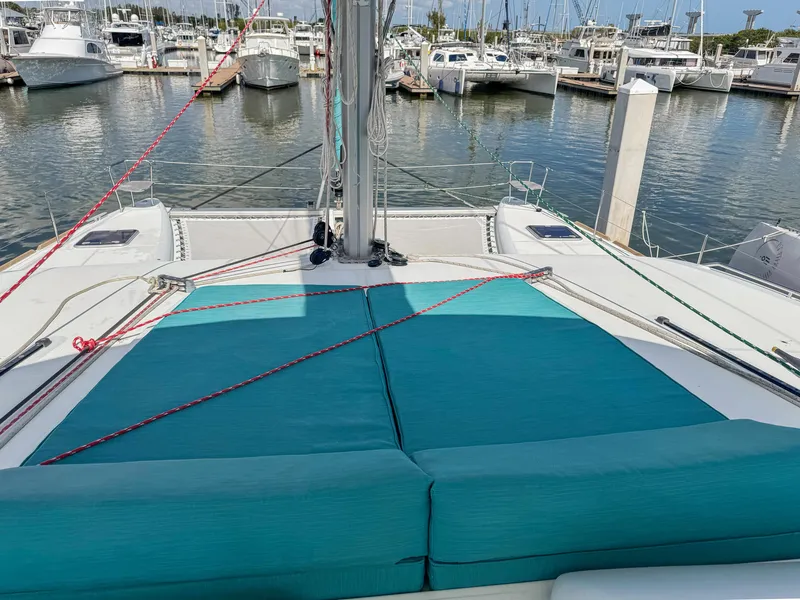 Slide: The Image of 2017 Lagoon 450 F catamaran with teal cushions docked at a marina. - 21