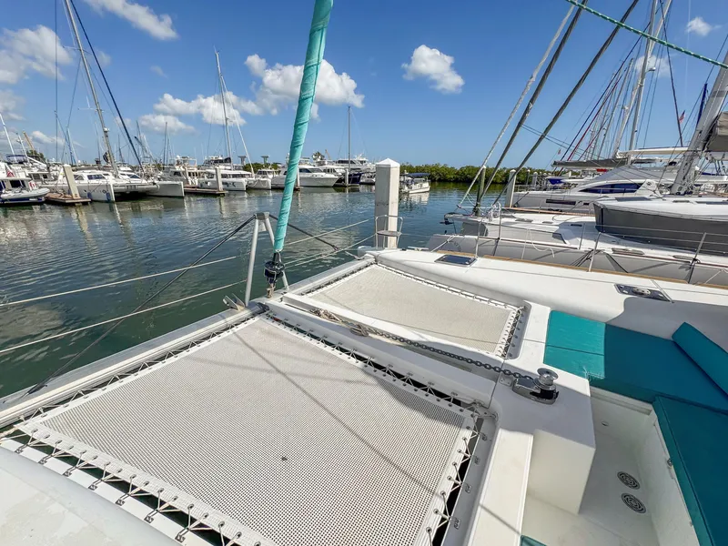 Slide: The Image of 2017 Lagoon 450 F catamaran docked in a marina under a clear blue sky. - 24